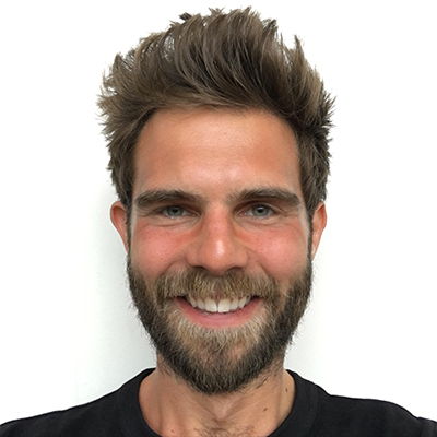 Marc Richards smiling, in the background his logo